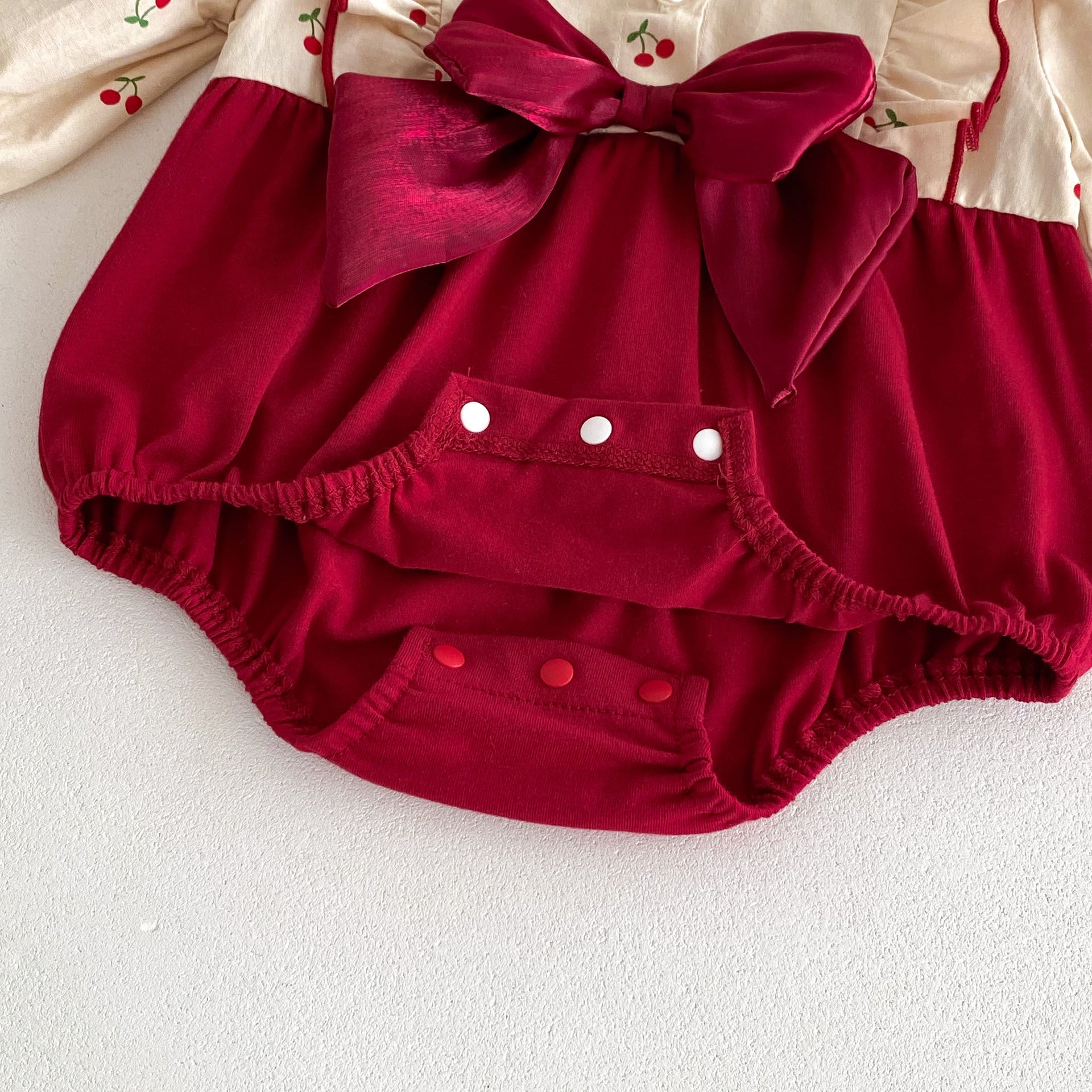 Enterizo con Moño Rojo y Estampado de Cerezas – Estilo Festivo para Bebé Niña